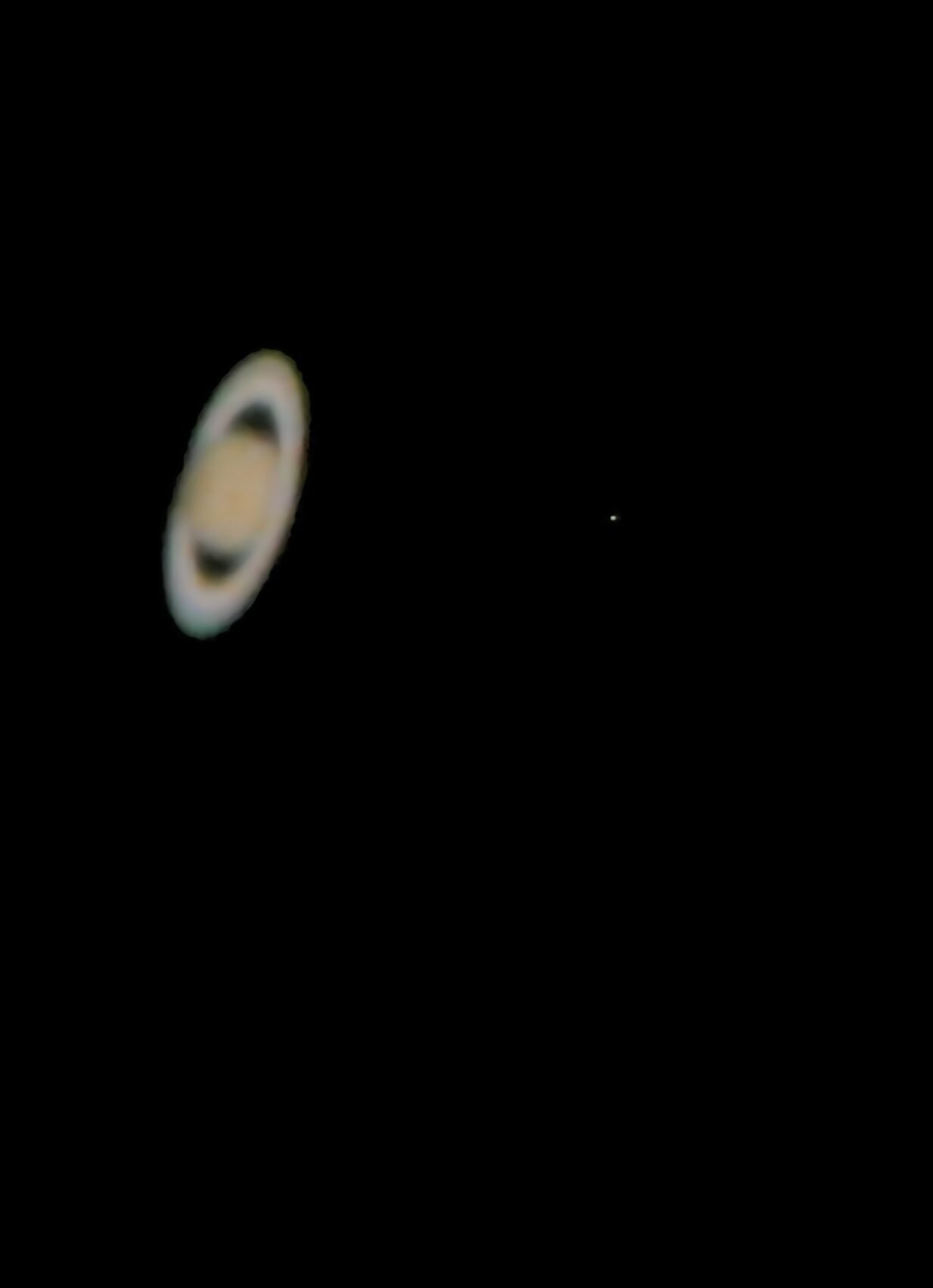 Telescopic image of Saturn and its rings, photographed with a Canon EOS Rebel T3i and Dobsonian telescope in 2005.